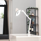 Lampe-loupe Lumeno 721X avec pince de table, allumée dans un séjour